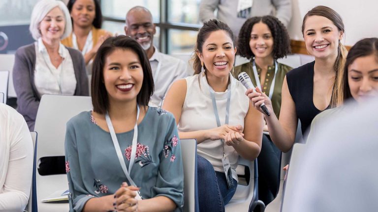 un gruppo di donne sedute su sedie per una conferenza