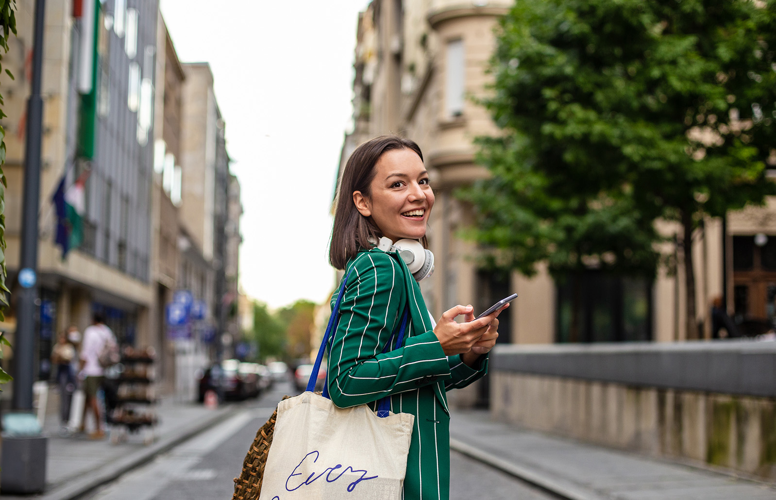 una donna che sorride mentre tiene in mano un telefono