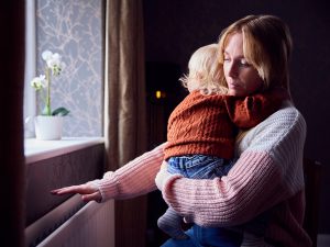 Madre con figlio che controlla il caldo dal radiatore a casa